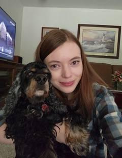 Girl holding dog and smiling at the camera